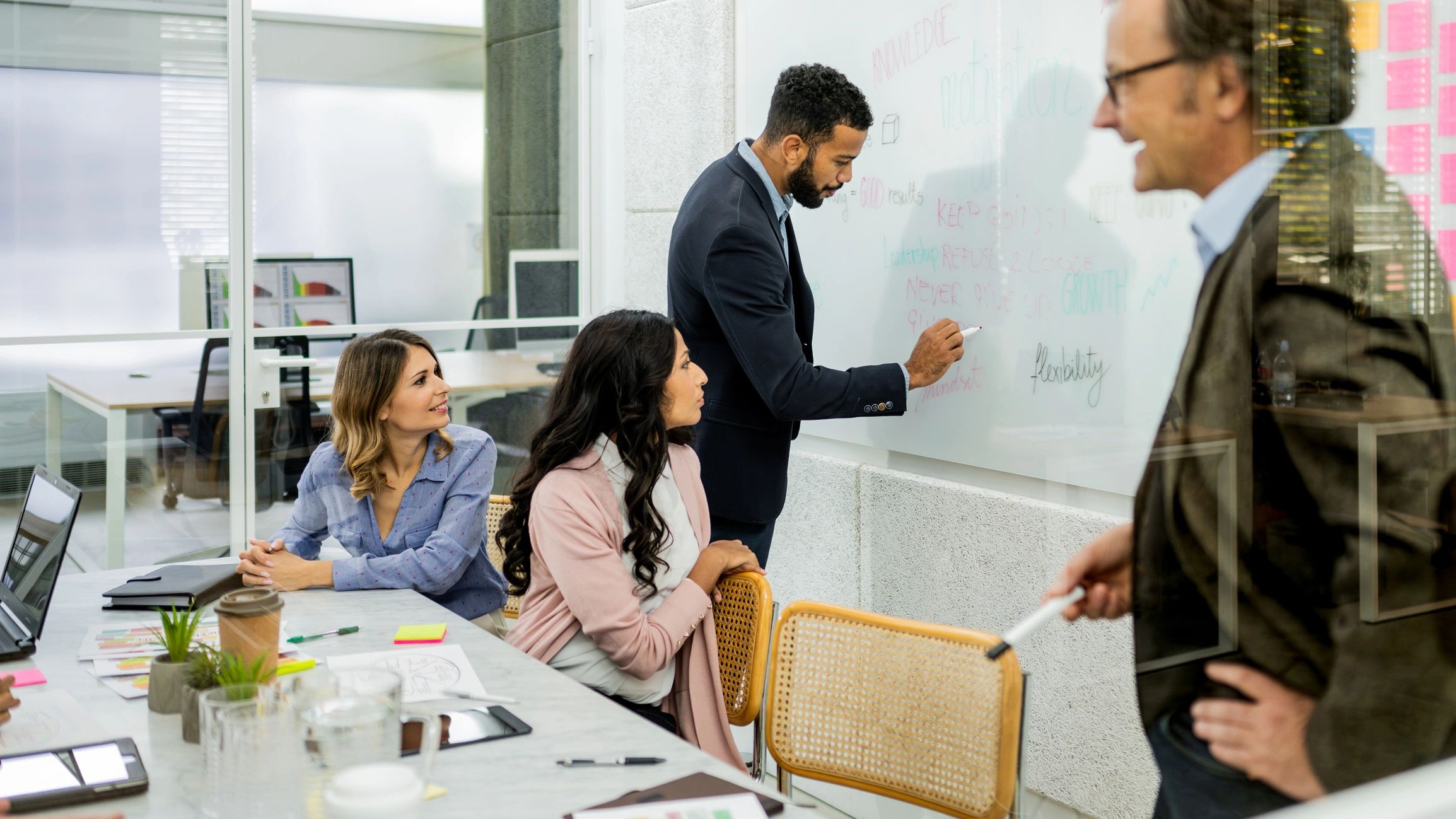 Team coordinating project plans in a conference room
