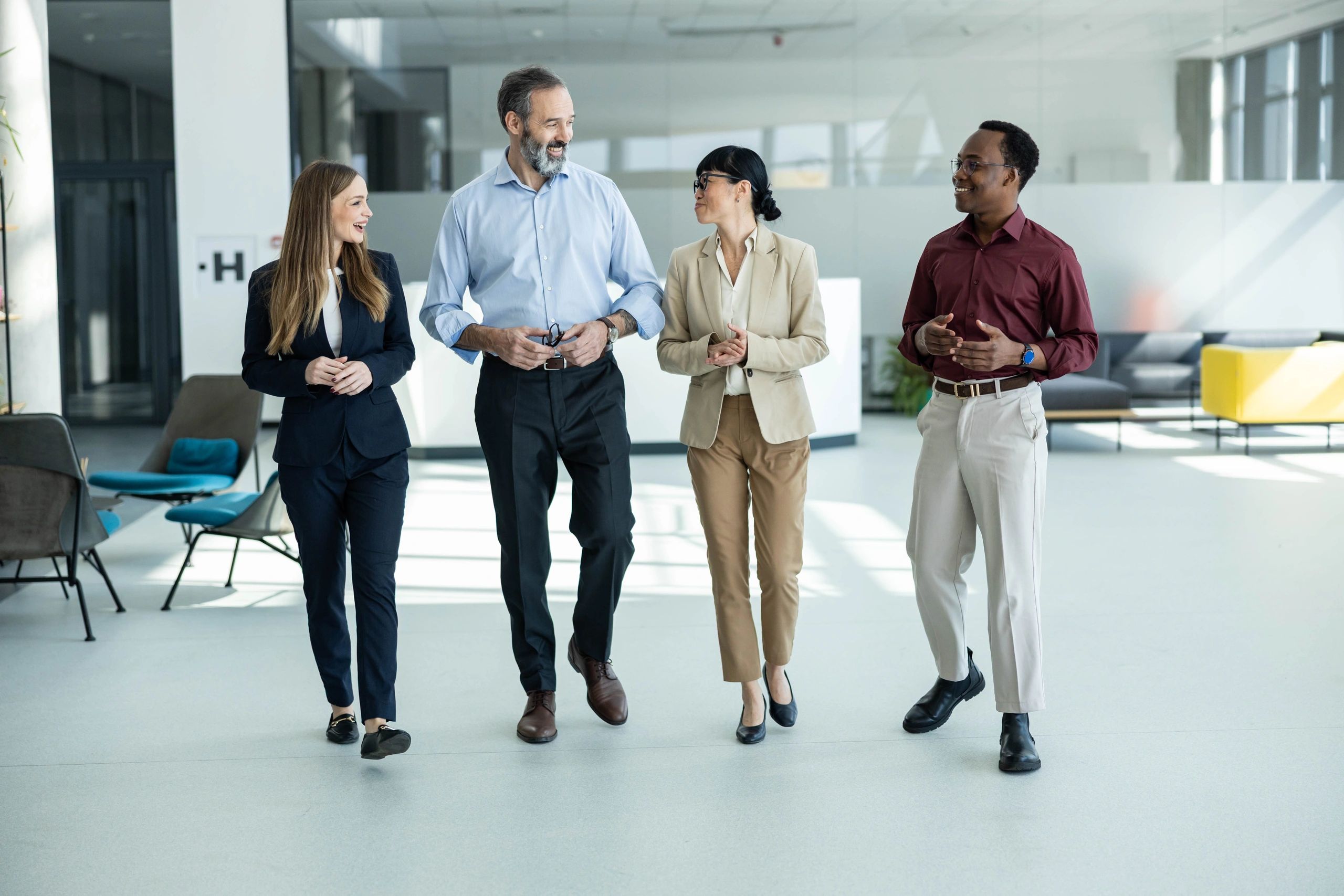 Diverse business team walking and discussing in office